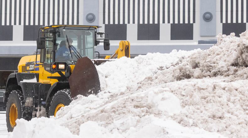 Snow is cleared from a parking lot in Grandville, Mich. on Monday Dec. 29, 2025. (Joel Bissell /MLive.com via AP)