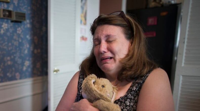 In this Wednesday, Sept. 2, 2015, photo, Dorothy McIntosh Shuemake, mother of Alison Shuemake who died of a suspected heroin overdose, cries as she clutches her daughter's toy stuffed rabbit during an interview at her home, in Middletown, Ohio. The Centers for Disease Control and Prevention has called heroin use a national epidemic and it is hitting hard in southern Ohio. The CDC says heroin-related deaths nationally nearly quadrupled in a decade; and in Ohio's Butler County, they have nearly quadrupled in just the past three years. (AP Photo/John Minchillo)
