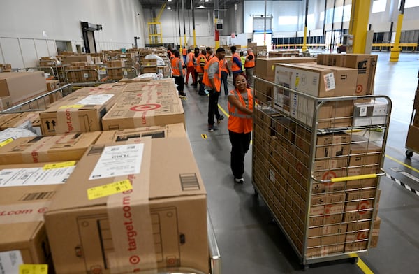 Workers prepare packages for delivery drivers at the Target sortation center in Lawrenceville on Friday, Nov. 21, 2025. (Hyosub Shin/AJC)