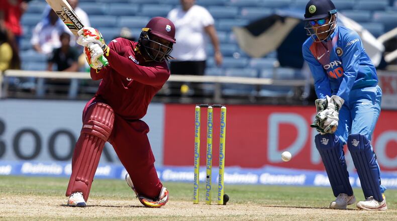 West Indies' Chris Gayle plays a shot under the watch of India's MS Dhoni during a T20I at Sabina Park cricket ground in Kingston, Jamaica, earlier this month. AP/Ricardo Mazalan