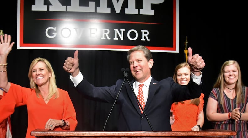 GOP gubernatorial candidate Brian Kemp gives a thumb up Tuesday as he takes the stage with his family during his election watch party in Athens. HYOSUB SHIN / HSHIN@AJC.COM