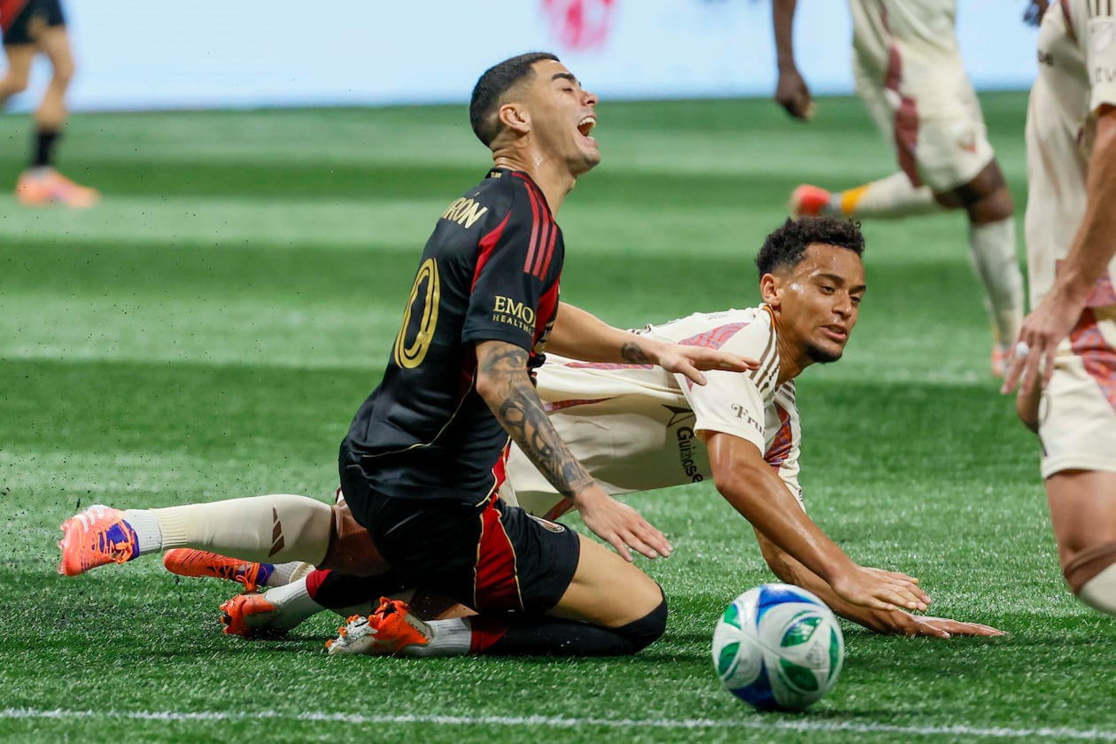 Midfielder Miguel Almirón (center, kneeling) — pictured reacting to a foul against D.C. United on Oct. 18 — was fourth on the list of highest salaries in MLS at $7.9 million behind Inter Miami's Lionel Messi ($20.4M), LAFC's Son Heung-min ($11.1M) and Miami's Sergio Busquets ($8.8M). (Miguel Martinez/AJC)