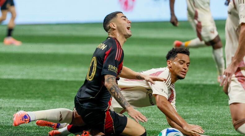 Midfielder Miguel Almirón (center, kneeling) — pictured reacting to a foul against D.C. United on Oct. 18 — was fourth on the list of highest salaries in MLS at $7.9 million behind Inter Miami's Lionel Messi ($20.4M), LAFC's Son Heung-min ($11.1M) and Miami's Sergio Busquets ($8.8M). (Miguel Martinez/AJC)