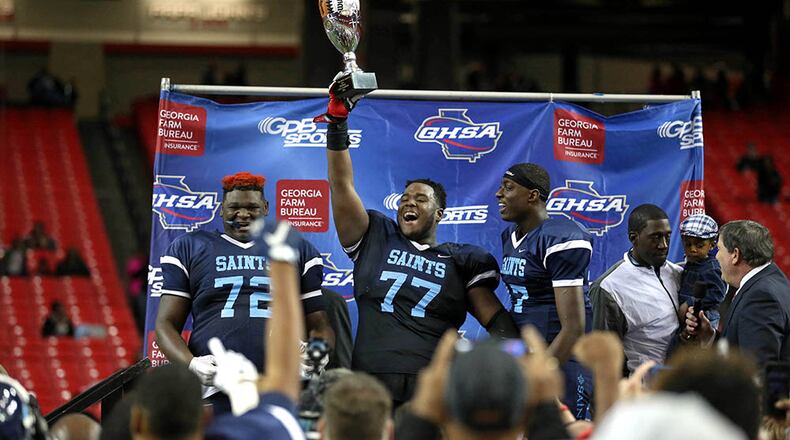Cedar Grove's Netori Johnson (72), Justin Shaffer (77) and Jelani Woods (17) celebrate their win against Greater Atlanta Christian during the Class AAA state championship game Friday at the Georgia Dome. (Jason Getz/Special)