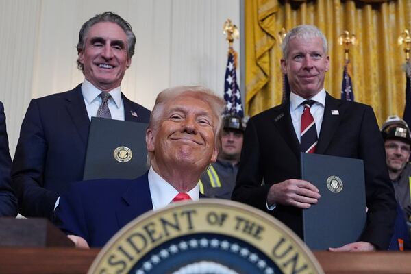 President Donald Trump smiles as he signs executive orders during an event in the East Room of the White House, Tuesday, April 8, 2025, in Washington, as Interior Secretary Doug Burgum and Energy Secretary Chris Wright watch. (AP Photo/Evan Vucci)