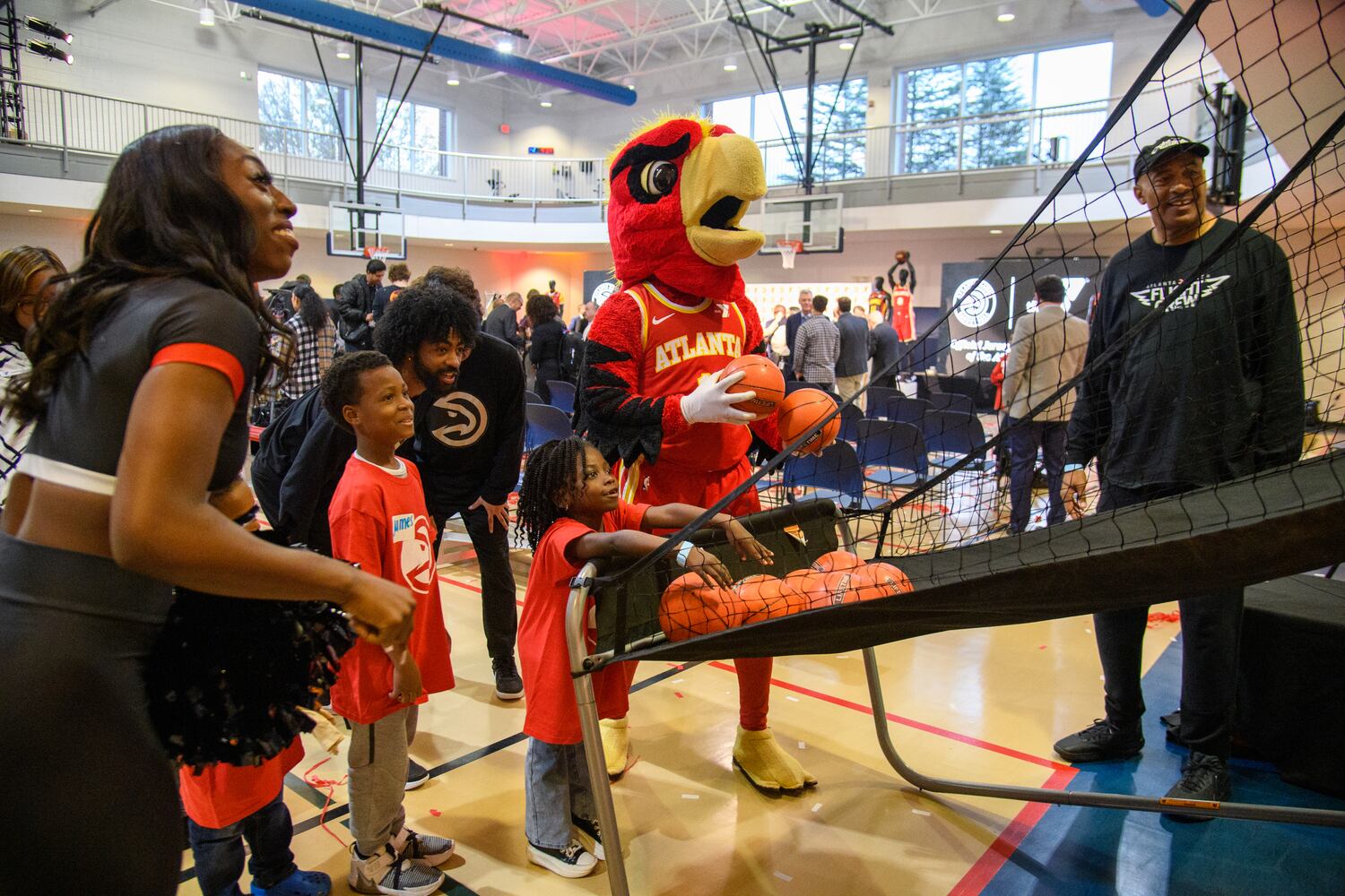 YMCA students play basketball with Harry, the Atlanta Hawks mascot, at the new sponsorship patch unveiling at The Villages at Carver Family YMCA in Atlanta, Georgia, November 20, 2023. (Jamie Spaar for the Atlanta Journal Constitution)