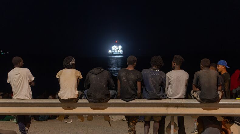 Migrants who crossed into Spain from Morocco gather on a beach in the Spanish enclave of Ceuta, Sunday, Aug. 2, 2026. (AP Photo/Antonio Sempere)