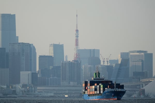 FILE - Tokyo Tower is seen amid tall buildings as a container ship leaves a cargo terminal in Tokyo, April 9, 2025. (AP Photo/Hiro Komae, File)