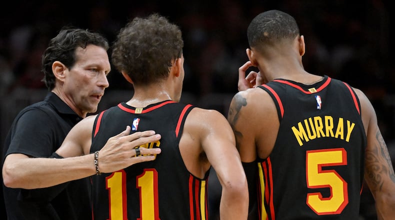 Atlanta Hawks coach Quin Snyder confers with Hawks guards Trae Young (11) and Dejounte Murray (5) during the second half in Game 3 of the first round of the Eastern Conference playoffs at State Farm Arena, Friday, April 21, 2023, in Atlanta. (Hyosub Shin / Hyosub.Shin@ajc.com)