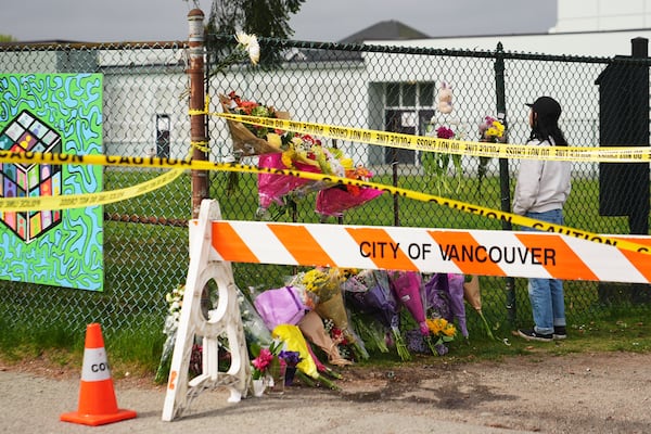 Sarah Edmilao, a member of the Filipino community who says friends had attended earlier in the day, views flowers at a growing memorial near a site the day after a driver killed multiple people during a Filipino festival Sunday, April 27, 2025, in Vancouver, British Columbia. (AP Photo/Lindsey Wasson)