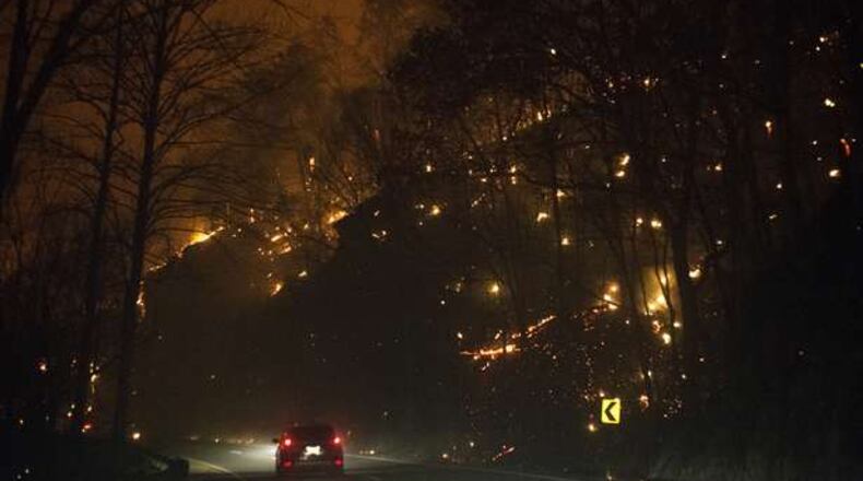 Fire erupts on both side of Highway 441 between Gatlinburg and Pigeon Forge, Tenn., Monday. In Gatlinburg, smoke and fire caused the mandatory evacuation of downtown and surrounding areas, according to the Tennessee Emergency Management Agency.