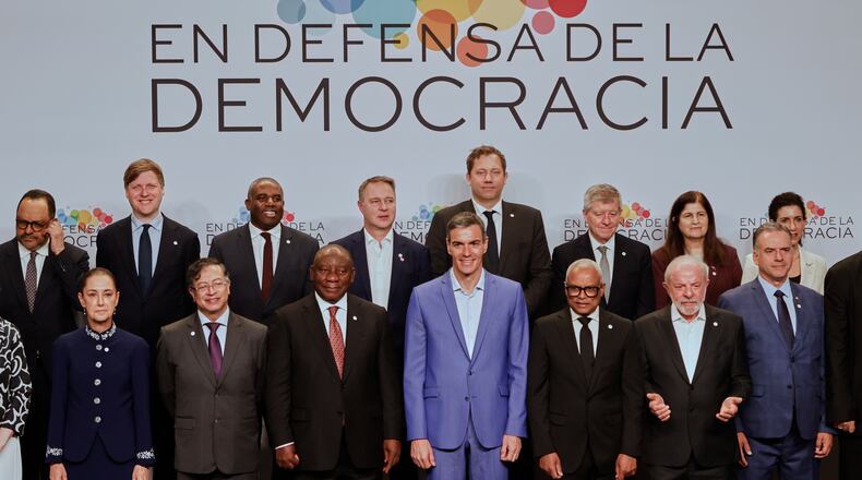 Spain's Prime Minister Pedro Sanchez, center, poses with attendees, at the Meeting in Defence of Democracy summit in Barcelona, Spain, Saturday, April 18, 2026. (AP Photo/Joan Monfort)