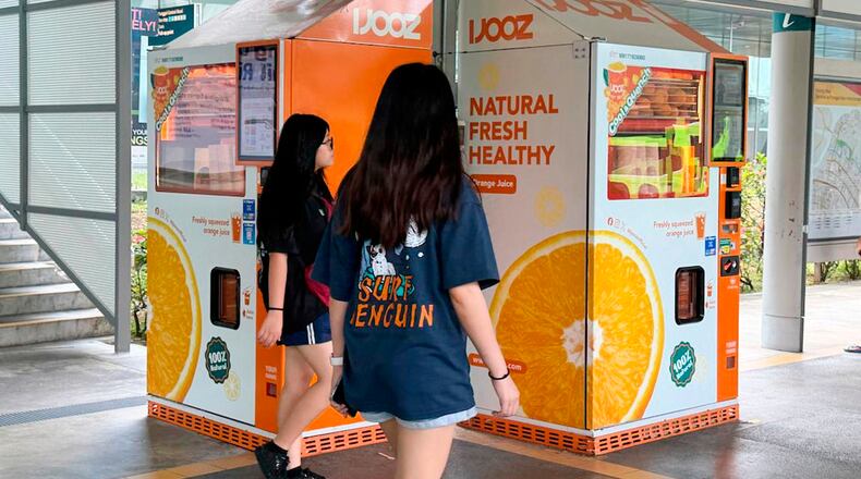 People walks past IJooz vending machines in Singapore, Thursday, April 30, 2026. (AP Photo/David Hu)