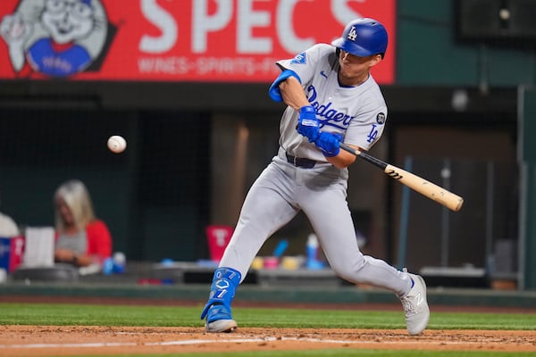 Los Angeles Dodgers' Tommy Edman swings at a pitch while hitting a single against the Texas Rangers during the sixth inning of a baseball game Friday, April 18, 2025, in Arlington, Texas. (AP Photo/Julio Cortez)