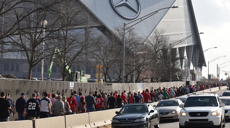December 2, 2017 Atlanta - Fans walk to Mercedes-Benz Stadium before Southeastern Conference championship NCAA college football game between Georgia and Auburn on Saturday, December 2, 2017. HYOSUB SHIN / HSHIN@AJC.COM