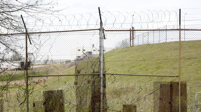 Patches of metal cover holes that minimum-security inmates cut into the fence around the Atlanta federal penitentiary's prison camp so they could escape and return with contraband. (David Barnes / For the AJC)