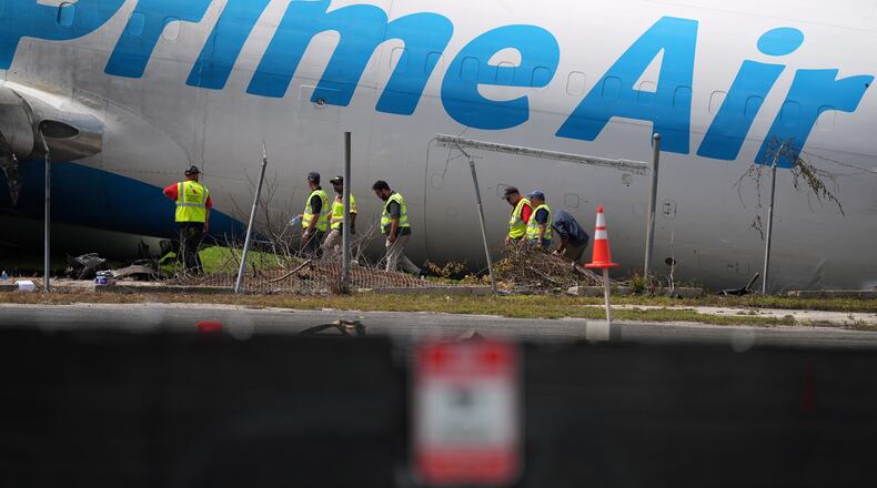 Workers inspect an Amazon cargo plane two days after it overshot a runway at Miami International Airport, Tuesday, Sept. 8, 2026, in Miami. (AP Photo/Rebecca Blackwell)