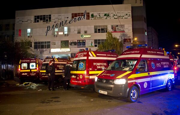 FILE - Ambulances are parked outside the site of a fire that occurred in a club, housed by the building in the background, in Bucharest, early Saturday, Oct. 31, 2015. (AP Photo/Vadim Ghirda, File)