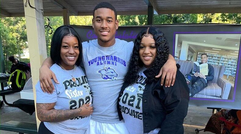 Artez Benton, center, poses with his sisters Arteria, left, and Bria after he graduated from Young Harris College last year.