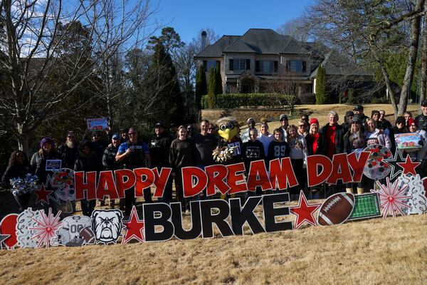 Bowie and his family take a group photograph behind a sign that says, “Happy Dream Day Burke,” during a sendoff by the College Football Playoff and Dream On 3 with a trip to the championship game at their home in Atlanta, Friday, Jan. 16, 2026. (Jason Getz/AJC)