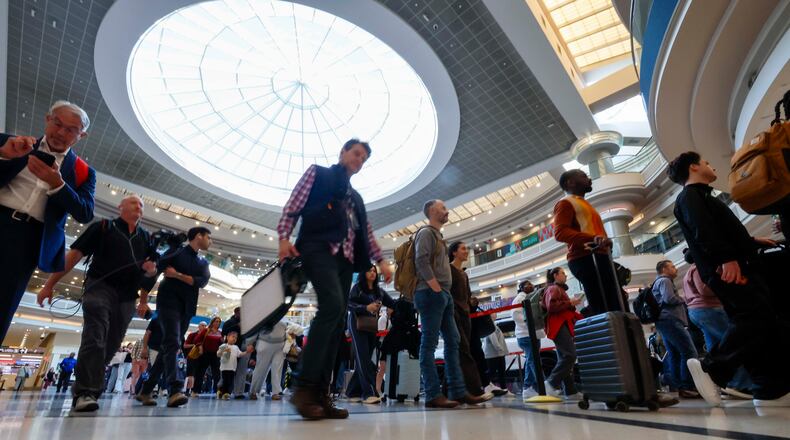 Travelers line up at the atrium approaching the Main checkpoint for security screening early Monday, March 23, 2026, at Hartsfield-Jackson Atlanta International Airport. The airport was again the world’s busiest in 2025 with 106.3 million passengers. (Miguel Martinez/AJC)