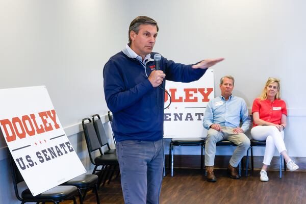Dooley speaks at a campaign stop at Farmview Market in Madison on May 8, 2026, as Kemp and his wife Marty look on. (Arvin Temkar/AJC)