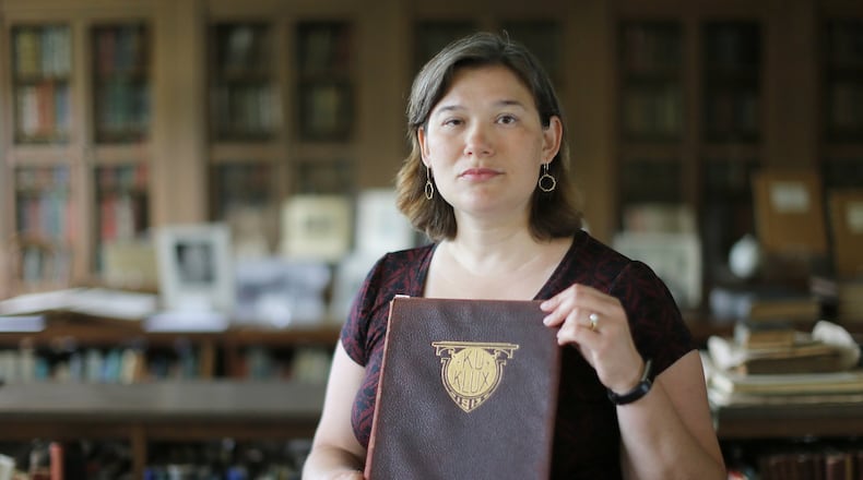 Karen Huber, Associate Professor of History at Wesleyan College, holds a 1913 yearbook titled “Ku Klux”. BOB ANDRES /BANDRES@AJC.COM