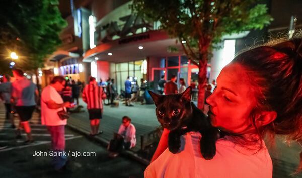 Kelli  Lusk holds her cat, Kizzy, as the two wait to re-enter their Midtown high-rise early Tuesday. JOHN SPINK / JSPINK@AJC.COM