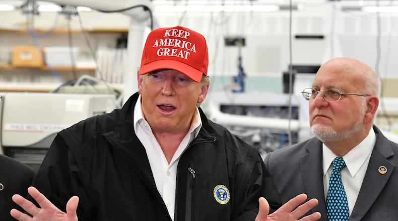 March 6, 2020 Atlanta - President Donald Trump speaks to members of the press as Director Robert Redfield (right) looks at the headquarters of the Centers for Disease Control and Prevention in Atlanta on Friday, March 6, 2020. President Donald Trump visited  the headquarters of the Centers for Disease Control and Prevention in Atlanta on Friday after all, after initially scrapping the trip over concerns that a staffer at the agency had contracted the coronavirus. (Hyosub Shin / Hyosub.Shin@ajc.com)