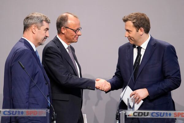 Friedrich Merz, Christian Democratic Union party chairman shakes hands with the Social Democratic Party co-leaders Lars Klingbeil, next to Markus Soeder, chairman of Bavarian's Christian Social Union party, after reaching an agreement between their parties on a coalition for a new German government at a news conference in Berlin, Germany, Wednesday, April 9, 2025. (AP Photo/Ebrahim Noroozi)