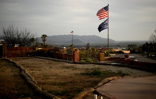 Flags fly along Esteban Drive after the Mountain Fire burned through the area Wednesday, April 16, 2025, in Camarillo, Calif. (AP Photo/Wally Skalij)