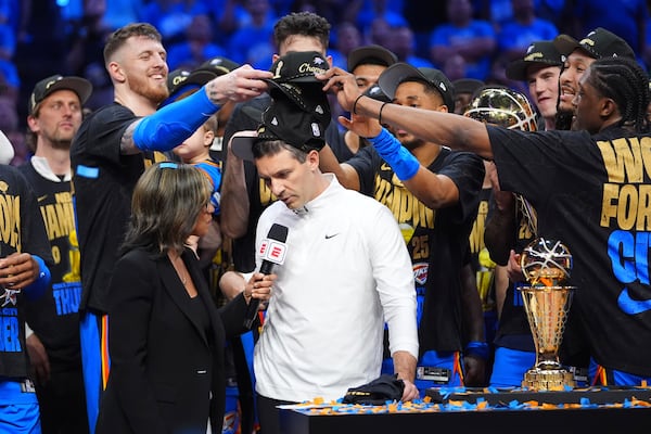 Oklahoma City Thunder players put hats on the head of head coach Mark Daigneault, center, as they celebrate winning the NBA basketball championship with a Game 7 victory against the Indiana Pacers Sunday, June 22, 2025, in Oklahoma City. (AP Photo/Julio Cortez)