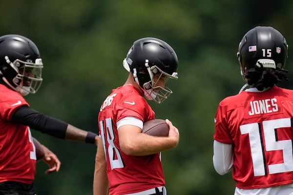 Atlanta Falcons quarterback Kirk Cousins, center, warms up during practice at NFL football minicamp, Tuesday, June 10, 2025, in Flowery Branch, Ga. (AP Photo/Mike Stewart)