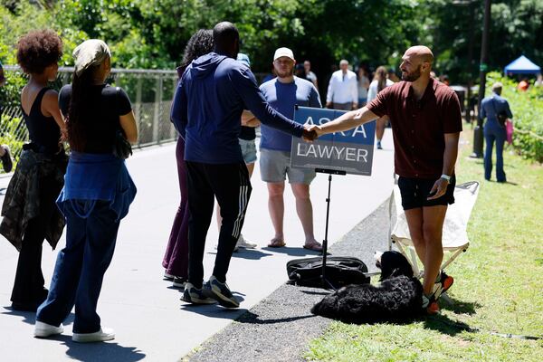 Beltline visitors begin to line up for attorney Cody Randall at his station on the Beltline on Sunday, May 3, 2026. Randall has gained fame as a social media celebrity for offering free legal advice to the public. (Miguel Martinez/AJC)