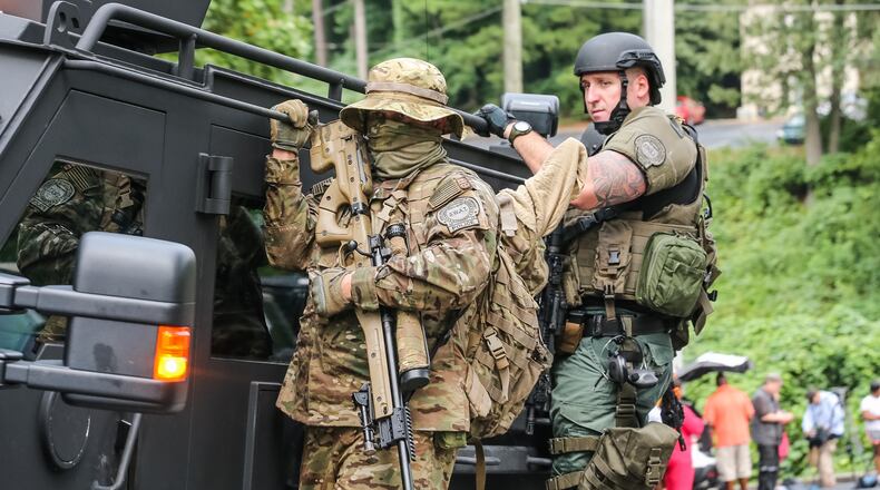 SWAT officers respond to a standoff in which a suspected gunman barricaded himself inside a Brookhaven apartment Tuesday. JOHN SPINK / JSPINK@AJC.COM