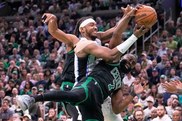 Boston Celtics guard Jaylen Brown (7) battles for a loose ball against Orlando Magic center Wendell Carter Jr. (34) during the first half in game 5 of a first-round NBA playoff basketball series, Tuesday, April 29, 2025, in Boston. (AP Photo/Charles Krupa)