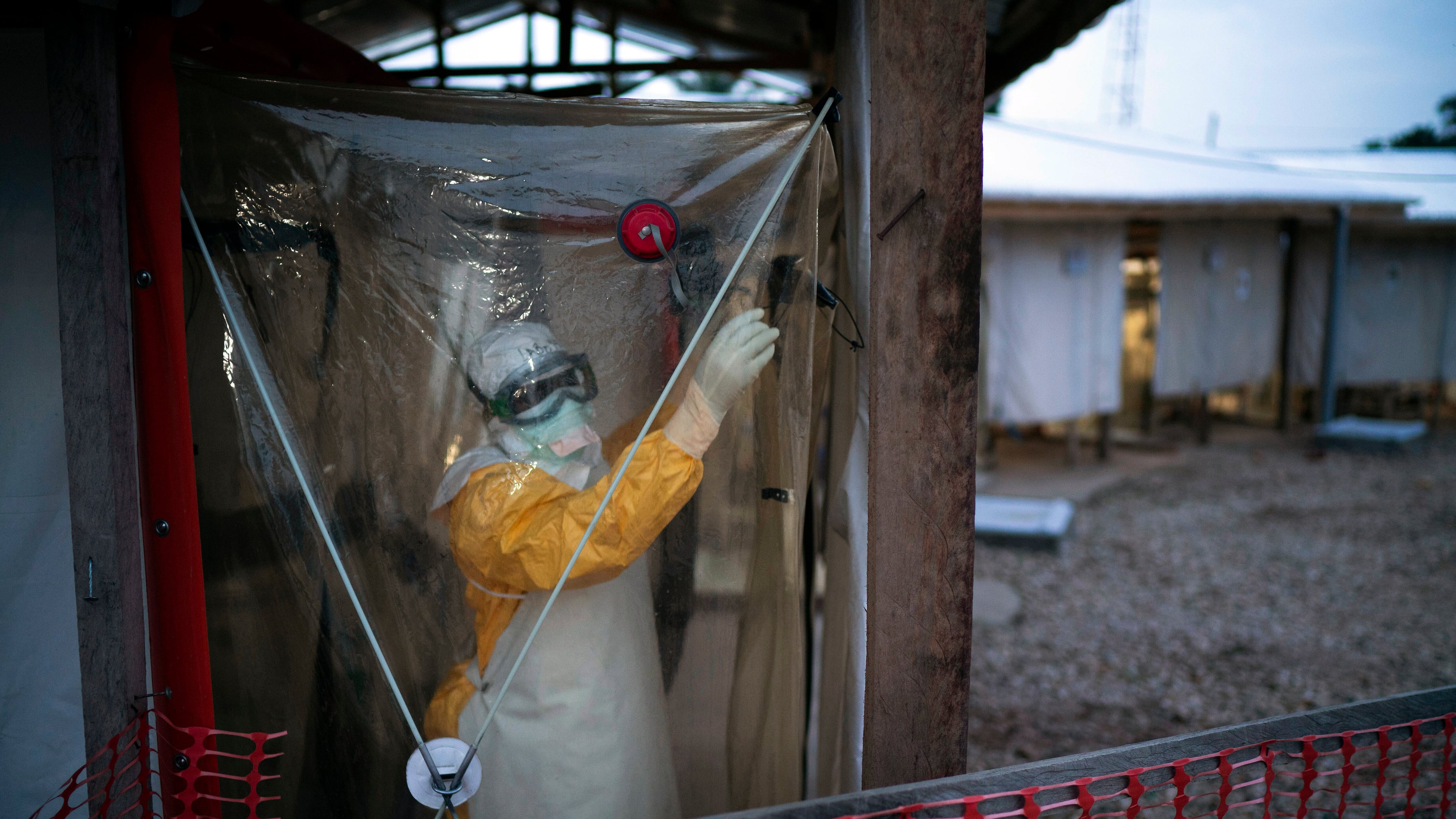 FILE - A health worker wearing protective suit enters an isolation pod to treat a patient at a treatment center in Beni, Democratic Republic of Congo, Saturday, July 13, 2019. (AP Photo/Jerome Delay, File)