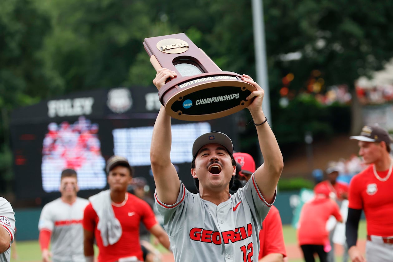 Georgia Bulldogs pitcher Caden Aoki lifts the trophy as he celebrates with his team after winning the NCAA Super Regional series, defeating the Mississippi State Bulldogs 11-9 at Foley Field on Sunday, June 7, 2026, in Athens. (Miguel Martinez/AJC)