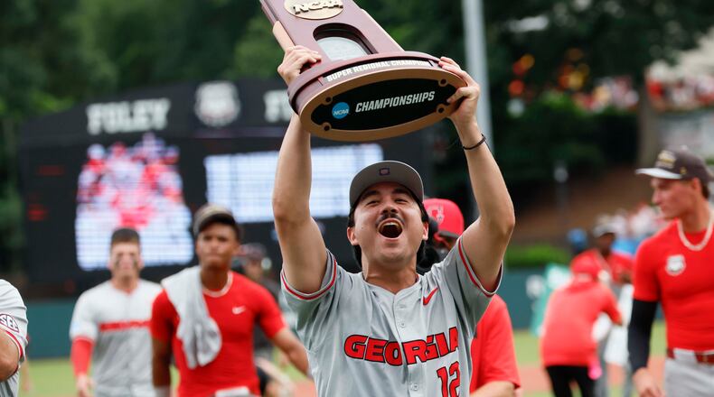 Georgia Bulldogs pitcher Caden Aoki lifts the trophy as he celebrates with his team after winning the NCAA Super Regional series, defeating the Mississippi State Bulldogs 11-9 at Foley Field on Sunday, June 7, 2026, in Athens. (Miguel Martinez/AJC)
