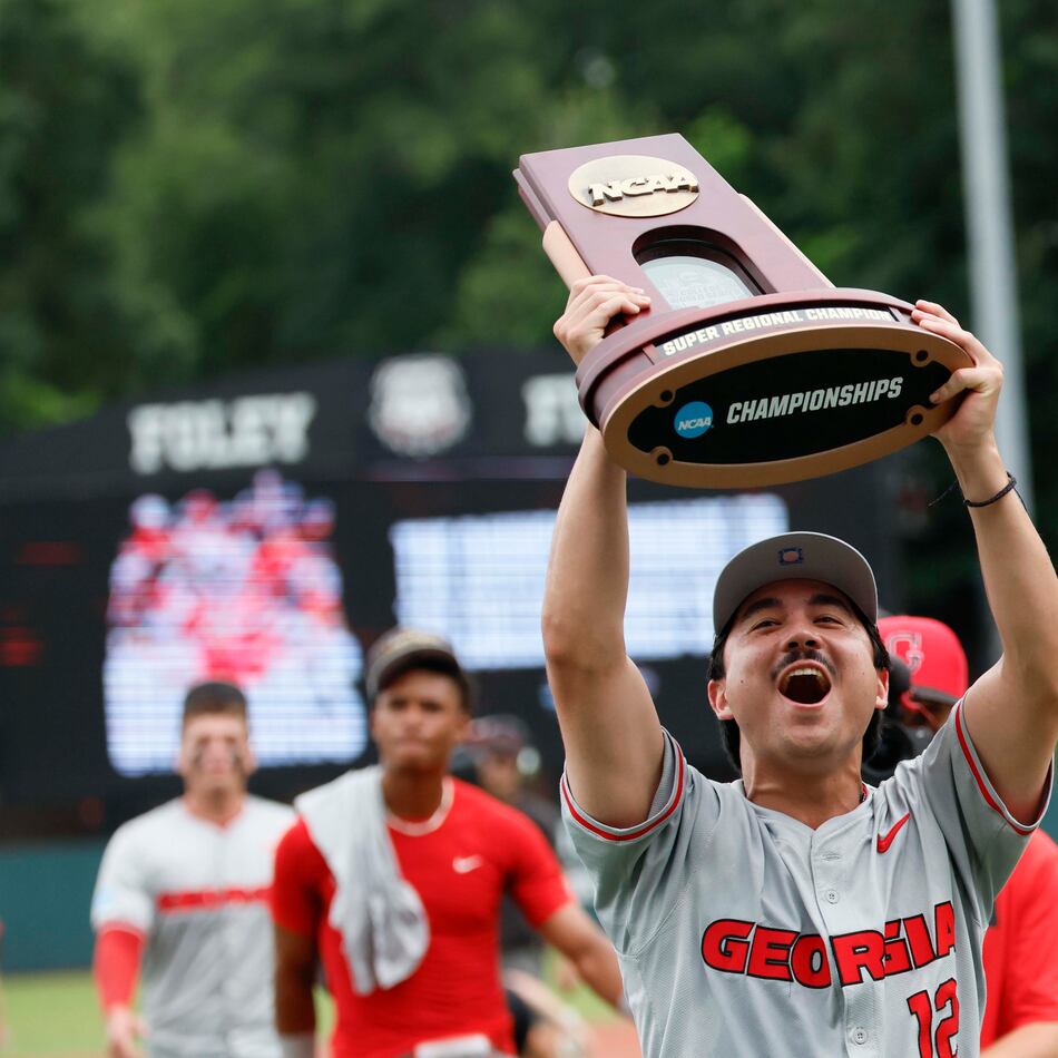 Georgia Bulldogs pitcher Caden Aoki lifts the trophy as he celebrates with his team after winning the NCAA Super Regional series, defeating the Mississippi State Bulldogs 11-9 at Foley Field on Sunday, June 7, 2026, in Athens. (Miguel Martinez/AJC)