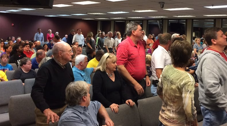Residents against a complex for disabled adults being built near a Hall County neighborhood stand in a county commission meeting to show their opposition. Photo by Bill Torpy.