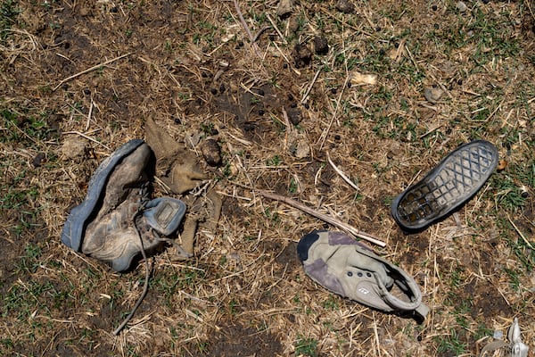 Worn out shoes are strewn in a field in the abandoned Samjung village, Mustang region, 462 kilometers (288 miles) west of Kathmandu, Nepal, Friday, April 18, 2025. (AP Photo/Niranjan Shrestha)