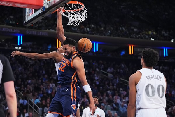 Dallas Mavericks' Max Christie (00) watches as New York Knicks' Karl-Anthony Towns (32) dunks the ball in front of Dallas Mavericks' Kai Jones during the first half of an NBA basketball game Tuesday, March 25, 2025, in New York. (AP Photo/Frank Franklin II)