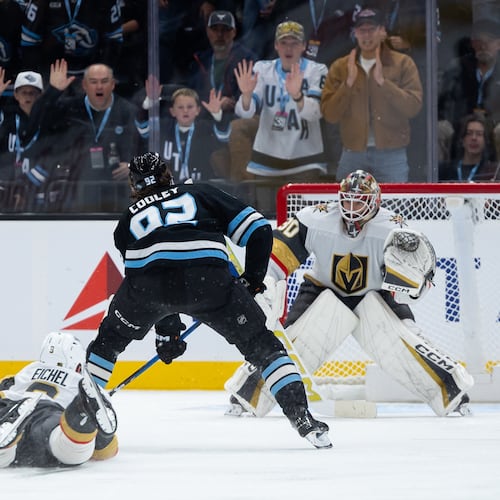 Vegas Golden Knights goalkeeper Carl Lindbom, right, prepares to defend a shot on goal as Utah Mammoth center Logan Cooley, center, takes the puck downice during the third period of an NHL hockey game, Monday, Nov. 24, 2025, in Salt Lake City. (AP Photo/Anna Fuder)