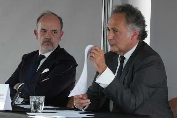Kylian Mbappe's lawyers Pierre Olivier Sur, right, shows a document as Thomas Clay looks on, during a press conference as Kylian Mbappe's legal team is going on the attack to try and solve the legal dispute between the World Cup winner and his former club PSG, Thursday, April 10, 2025 in Paris. (AP Photo/Michel Euler)