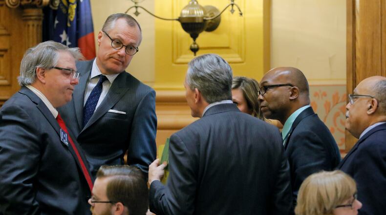 Senate members, including (from left) Sen. Steve Henson, D-Stone Mountain, Lt. Gov. Casey Cagle, Sen. Jesse Stone, R-Waynesboro, Sen. Elena Parent, D-Atlanta, Sen. Harold V. Jones II, D-Augusta, and Sen. Vincent Fort, D-Atlanta huddle on Thursday, the 40th and final legislative day of the 2017 General Assembly.   BOB ANDRES  /BANDRES@AJC.COM
