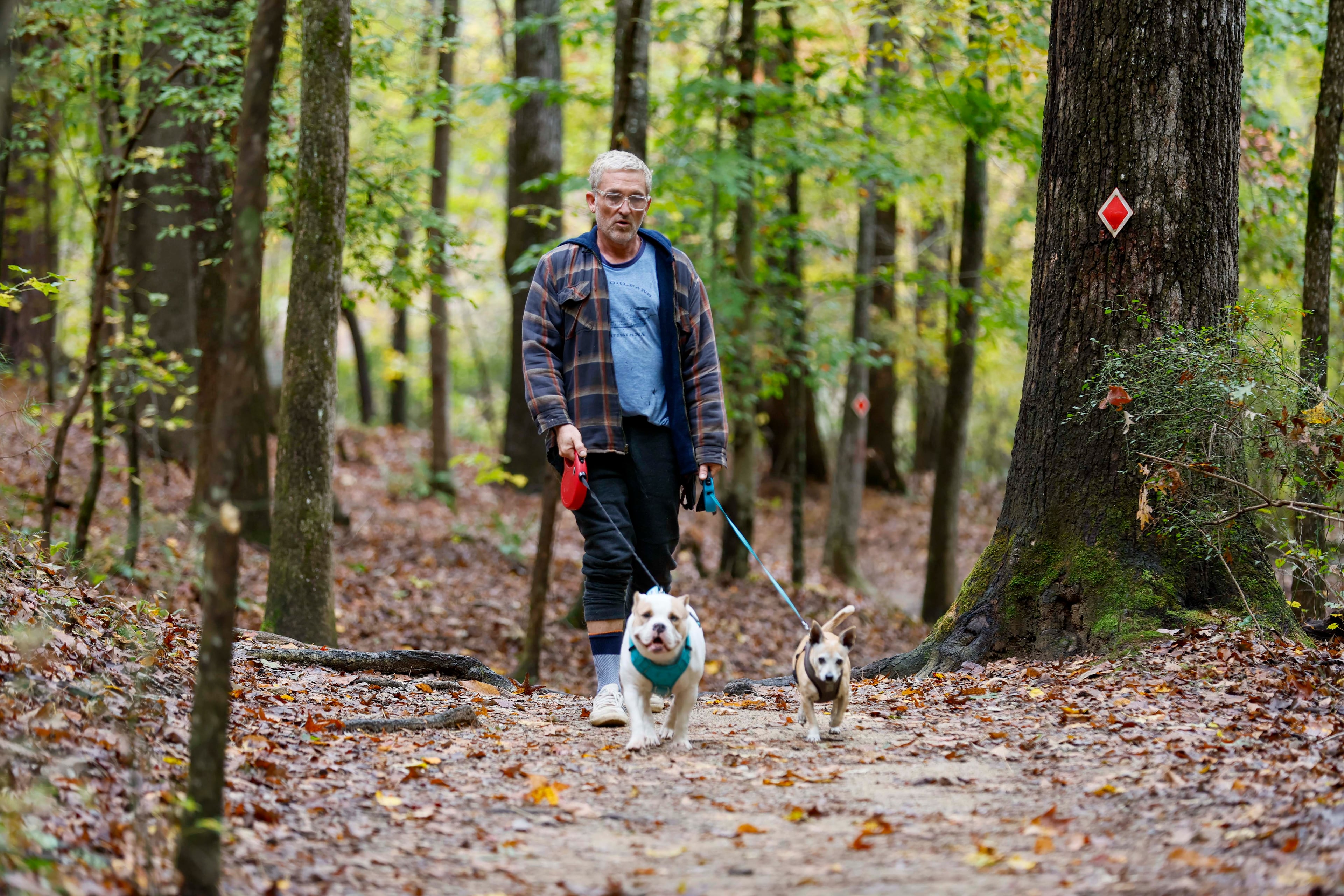Terrance Wahl of Decatur takes a walk with his pets, Teddy and Tippi, at Sweetwater Creek State Park on Thursday, Oct. 30, 2025. He visits the park four to five times a year. (Miguel Martinez/AJC)