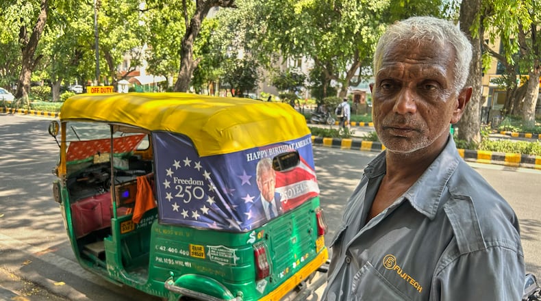 Ganesh Kumar stands next to his auto-rickshaw featuring a poster of U.S. President Donald Trump that celebrates "250 Years of America" on the back of his vehicle in New Delhi, India, Wednesday, May 20, 2026. (AP Photo/Piyush Nagpal)