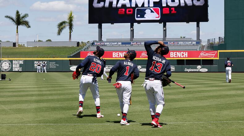 Braves outfielder Marcell Ozuna (from left), second baseman Ozzie Albies and outfielder Ronald Acuna watch out for a pop fly at CoolToday Park during a spring training workout March 14 in North Port, Fla. All three are ranked among baseball's "top 10 players right now" at their positions by MLB Network. (Curtis Compton / Curtis.Compton@ajc.com)