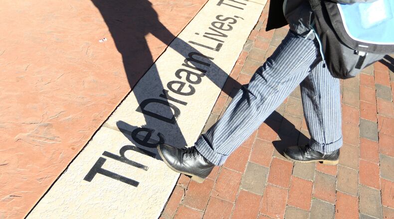 A passerby walks in 2019 across an inscription in front of the crypt of Dr. Martin Luther King Jr. and Mrs. Coretta Scott King in Atlanta. EMILY HANEY / emily.haney@ajc.com